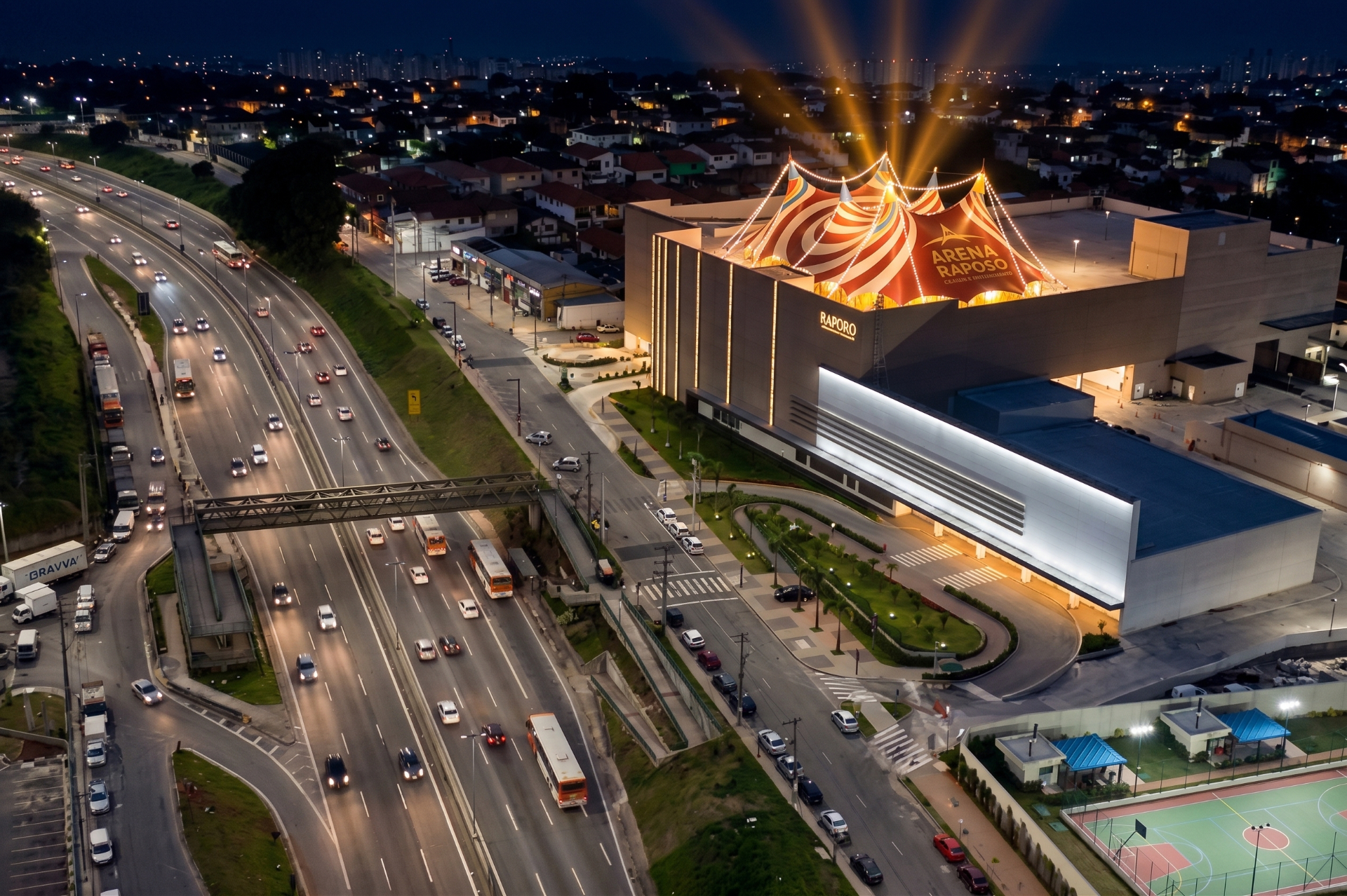Vista aérea noturna da Arena Lona Raposo, com a tenda iluminada ao lado da Rodovia Raposo Tavares